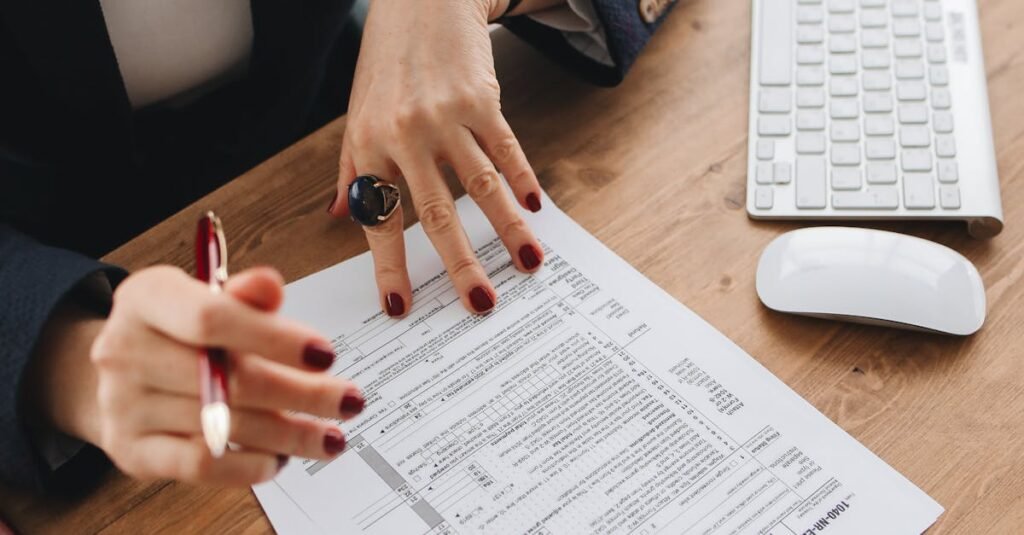 Close-up-of-a-professional-examining-tax-documents-on-a-wooden-desk-indoors